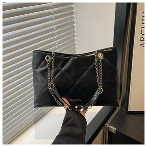 Détail du cabas noir matelassé avec chaîne dorée et gravure Fashion élégante