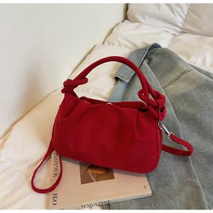 Detail of red faux suede cloud bag with pleated design and unique knotted top handle