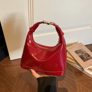 Maillard red glossy patent leather bucket handbag with embossed logo and metal hardware