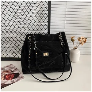Détail du sac à bandoulière noir plissé avec fermoir tournant doré et bandoulière chaîne