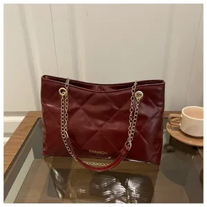 Gros plan du sac cabas matelassé rouge foncé avec bandoulière chaîne et texte fashion