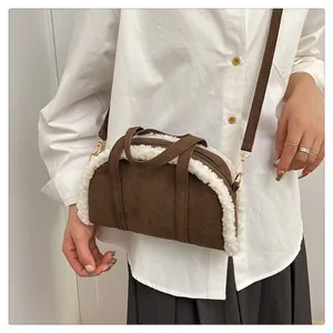 Détail du sac à main en daim marron avec bordure en similicuir laineux et boucles dorées