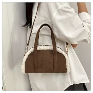 Détail du sac à main rétro en daim avec bordure en fausse fourrure et boucles dorées