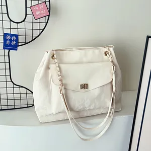 Grand sac cabas beige minimaliste avec fermoir pivotant doré et bandoulière en chaîne