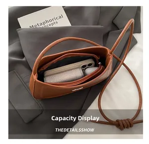 Top view of brown leather bag interior showing large capacity and internal zip pocket