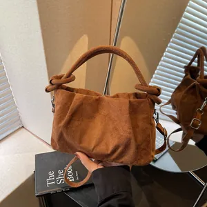 Retro brown faux suede crossbody bag featuring knot handles and a pleated cloud shape