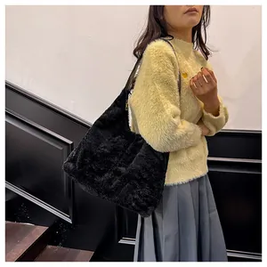 Detail of a large black plush tote bag with a zipper closure and soft faux fur texture