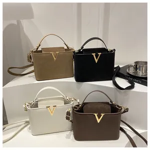 Vue détaillée de sacs seaux de luxe en quatre couleurs avec boucles en V dorées