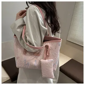 Detail of pink tote bag featuring quilted texture and colorful wavy stitching accents