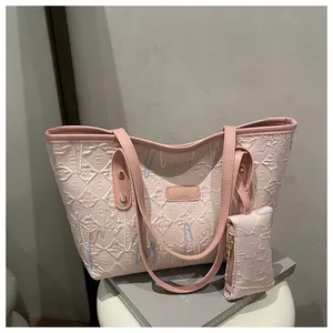 Pink tote bag detail with colorful wave embroidery, quilted texture, and mini coin purse