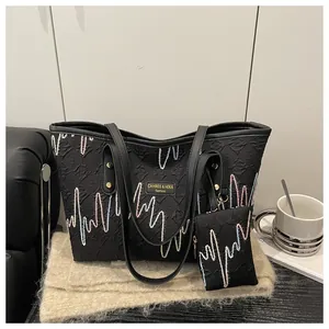Detail of black tote bag with colorful embroidery on premium textured material