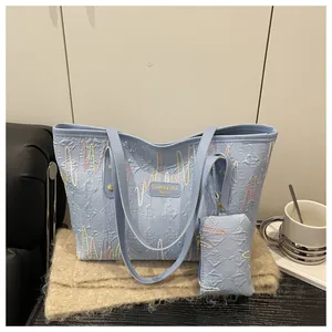 Detail of light blue quilted tote bag with wavy patterns on a soft beige scarf
