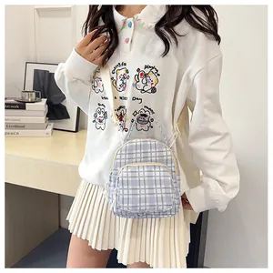 Dettaglio del mini zaino in tela a scacchi azzurro con spalline regolabili e tasche zip