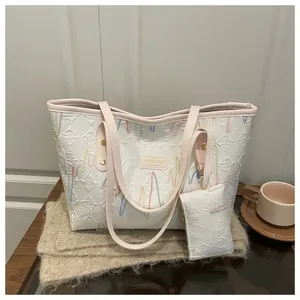 Detail of white tote bag with colorful wave embroidery and matching mini accessory pouch