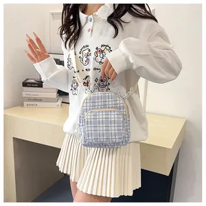 Dettaglio mini zaino a quadri blu indossato a tracolla con uno stile scolastico fresco