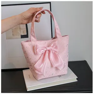 Detailed view of pink star pattern tote bag featuring a large satin ribbon bow accent