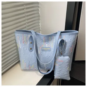 Detail of light blue tote bag with 3D texture and colorful wavy stitching accents