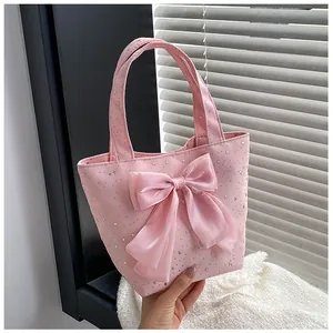 Detailed view of pink star sequin handbag with large satin bow and soft handles