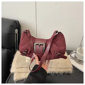 Détail du sac à bandoulière bordeaux en daim avec boucle métallique rétro