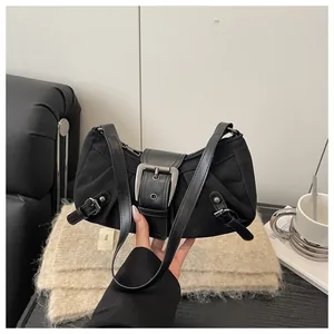 Gros plan d'un sac sous le bras en toile noire avec plis et grande boucle métallique