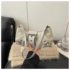Détail d'un sac sous le bras vintage crème en cuir mat avec des boucles métalliques chic