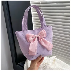Detail of lavender star sequin tote bag featuring a large pink satin decorative bow