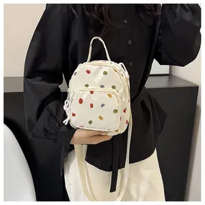 Dettaglio del mini zaino crema a pois colorati con sistema di cerniera scorrevole