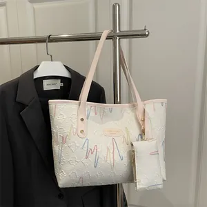 Minimalist white tote bag with colorful stitching and pink shoulder strap detail