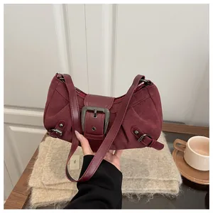 Détail du sac bandoulière en daim bordeaux avec boucle en métal vintage et forme de lune