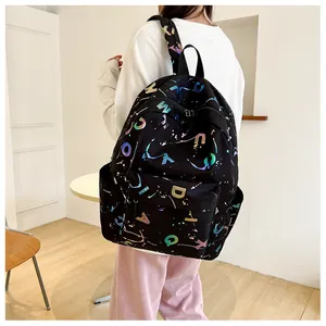 Detail of black canvas backpack featuring colorful holographic letter prints and side pocket