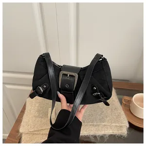 Détail du sac sous le bras noir Y2K avec boucles métalliques et texture en toile