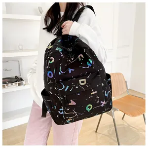 Detail of black canvas backpack with colorful holographic letters and artistic ink splashes