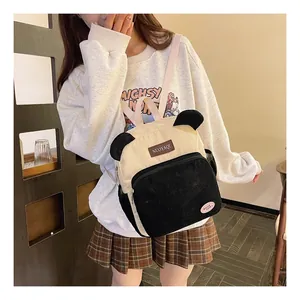 Detailed look at corduroy panda backpack showing front zipper pocket and cute ears