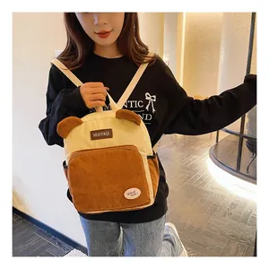 Detail of corduroy backpack featuring contrast colors and cute bear ear decorations