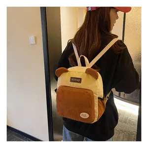Detail of corduroy backpack showing cute bear ears and contrast front pocket design