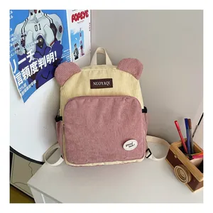 Detail of yellow and pink corduroy backpack with cute bear ears and brand patch