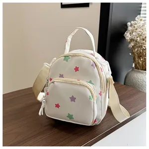Dettaglio di un mini zaino bianco con motivi a stelle colorate su base di legno