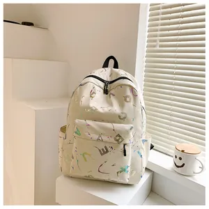 Close-up of cream canvas backpack with colorful abstract letter prints and front pocket