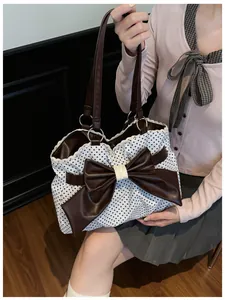 Close-up of polka dot tote bag featuring a large brown bow and white lace trim detail