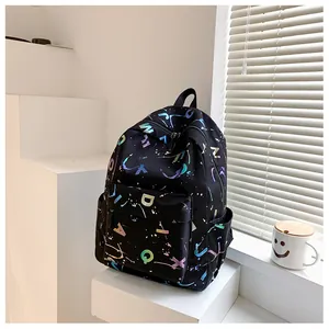 Detail of black backpack featuring holographic letter prints and starry ink splash pattern