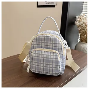 Dettaglio mini zaino a scacchi blu e bianchi con spallacci intrecciati e cerniere