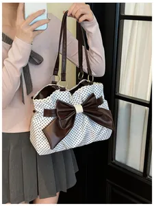 Close-up of polka dot tote bag with large brown bow and elegant lace trim detail