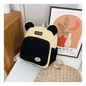 Detail of panda-style corduroy backpack showing soft texture and decorative labels