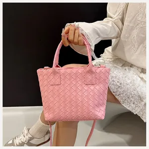 Detail of pink woven leather texture and handles on a luxury designer tote bag