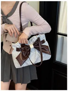 Detailed view of the vintage polka dot tote featuring a leather bow and lace trim