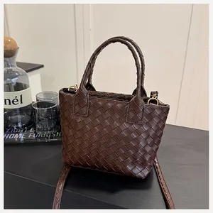 Close-up of dark brown woven leather tote with circular handles and interior detail