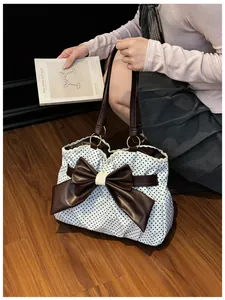 Polka dot tote bag detail showing the large leather bow and delicate lace trim