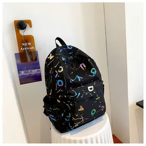 Detail of black printed backpack with holographic lettering on a white pedestal