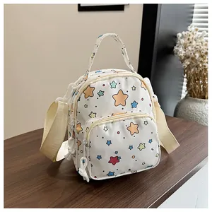 Dettaglio di un mini zaino in tela con stelle e doppia cerniera su un tavolo