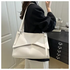 Détail du sac fourre-tout blanc avec rabat géométrique et bandoulière à boucle métallique